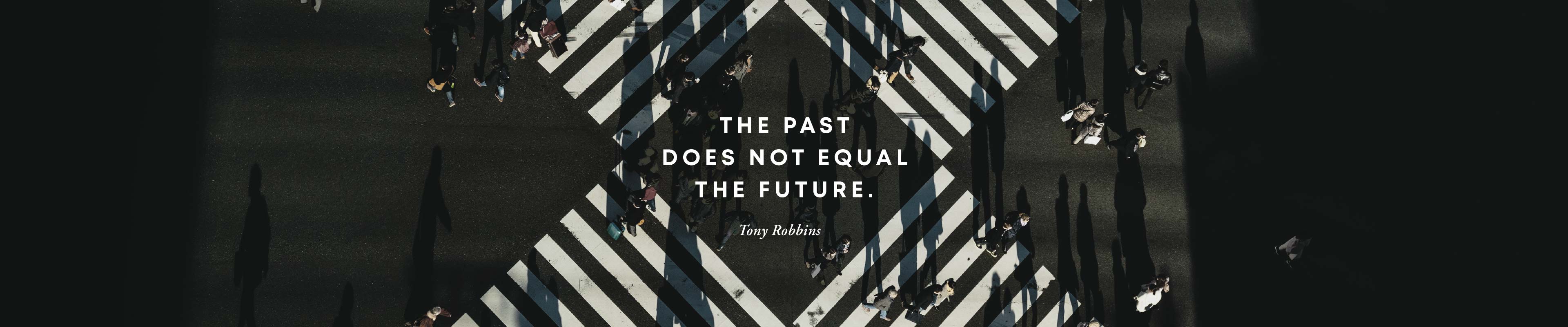 Overhead view of street intersection with quote overlay from Tony Robbins&colon; &ldquo;The past does not equal the future&rdquo;