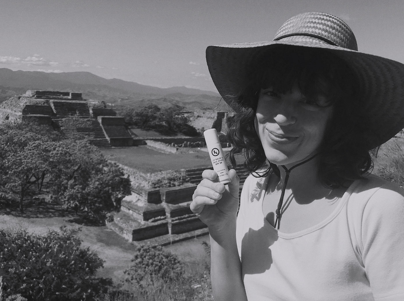 Photo of Denise holding the AKT Therapy Lip Balm and Face Stick in front the ruins at Monte Alban in Oaxaca&comma; Mexico